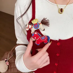 Set of two cute embroidered horse brooch pins on a red knit vest for autumn/winter fashion