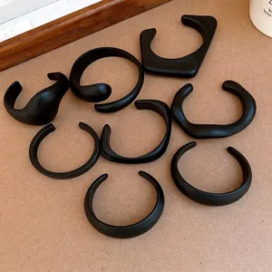 Minimalist matte black acrylic open bangles in various artistic geometric shapes