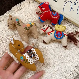 Cute handmade fabric horse brooches with floral embroidery and gold ingot detail