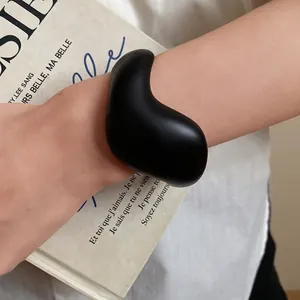 Elegant minimalist black acrylic open bracelet featuring an organic pebble-shaped design