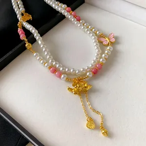 Vista dettagliata della collana di perle artificiali in stile cinese con pendente a loto dorato