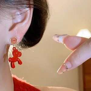 Detailed view of red enamel horse earrings featuring a traditional Chinese Fu character stud