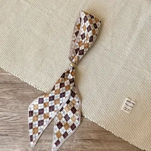 Close-up macro of retro argyle pattern silk scarf necklace with an elegant gold ring