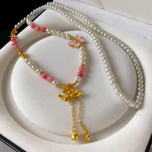 Dettaglio della collana di perle finte con loto e farfalla stile nuovo cinese