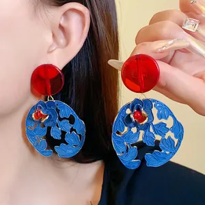 Close-up detail of vintage Chinese style resin flower and leaf drop earrings on model