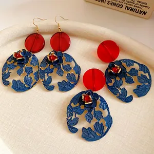 Close-up of New Chinese style floral earrings with red resin beads and blue leaf patterns