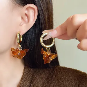 Detailed close-up of vintage amber acrylic flower earrings with gold hoop on model