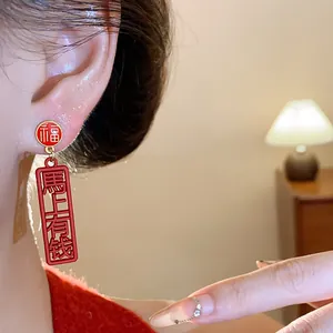 Detail of red New Chinese style earrings with Fu and prosperity characters on ear