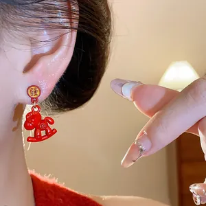 Close-up view of red enamel horse earrings featuring traditional Chinese characters