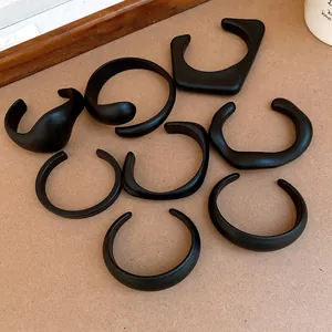 Detailed view of assorted black matte acrylic open bangles in minimalist geometric shapes
