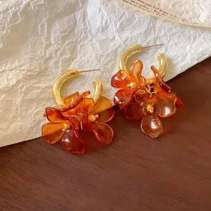 Detailed close-up showing French retro amber acrylic flower charms on golden hoop earrings