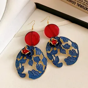 Detailed view of vintage Chinese style earrings with blue floral and red resin elements.