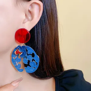 Close-up of vintage New Chinese style resin flower and leaf earrings on an Asian model.