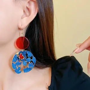 Detail view of New Chinese style floral earrings with red resin and blue enamel.