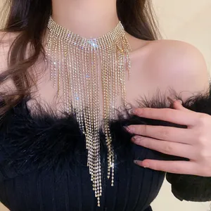 Vista dettagliata di una collana con nappe di strass esagerata indossata su una modella.