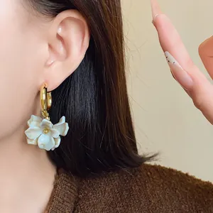 Detailed close-up of French vintage acrylic marbled flower earrings on model's ear