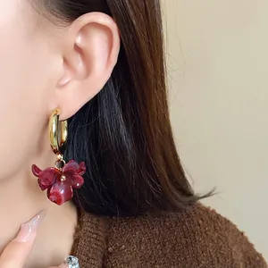 Detailed close-up of French retro acrylic ink-wash floral hoop earrings on a model's ear