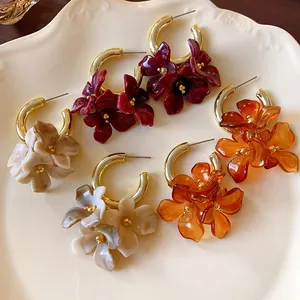 Detail view of retro french style marbled acrylic flower hoop earrings on a plate