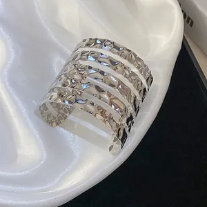 Close-up detail of hammered silver wide cuff bracelet with multi-layered band design