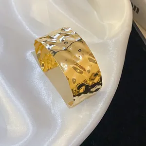 Close-up of golden hammered texture cuff bracelet with irregular geometric design