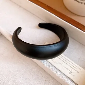 Close-up detail showing the smooth matte finish of a black acrylic open bangle