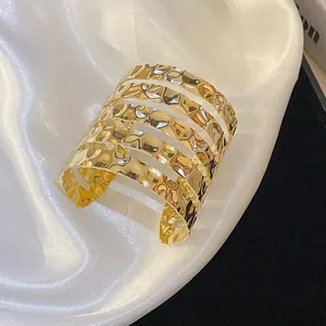 Detailed view of gold hammered multi-layered open cuff bracelet with irregular texture.