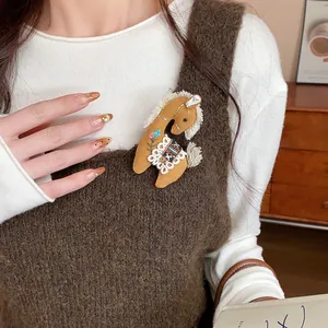 Close-up of a cute fabric horse brooch with embroidery pinned to a knitted vest.