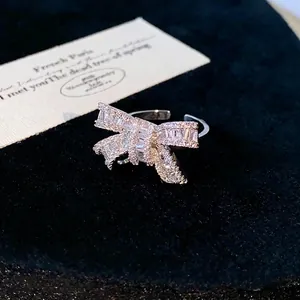 Elegant silver-toned bowknot open ring with sparkling cubic zirconia stones on black background