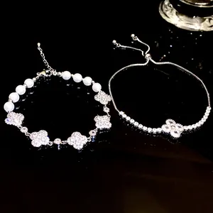 High-end detail view of elegant pearl and zircon four-leaf clover bracelets on dark surface