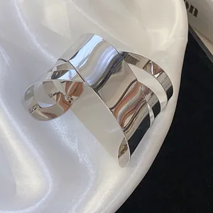 Detailed macro view of an irregular geometric silver cuff bracelet with a polished finish