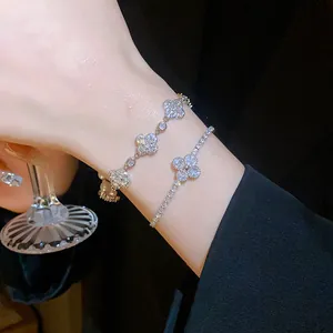Elegant close-up view of two zircon four-leaf flower bracelets worn on a wrist