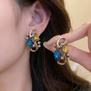 Vintage court style earrings with colorful rhinestones in an antique gold finish.