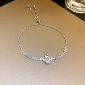 Close-up of elegant silver-tone four-leaf flower bracelet with sparkling zircon stones
