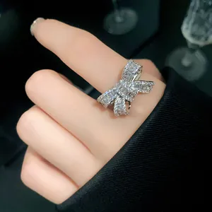 Detailed macro shot of a sparkling silver butterfly bow zircon open ring on finger