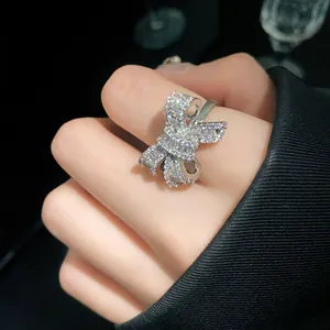 Macro detail of a silver bow-shaped hollow open ring with sparkling cubic zirconia