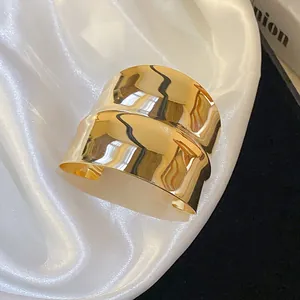 Macro view of gold irregular wrinkled geometric open cuff bracelet with glossy finish