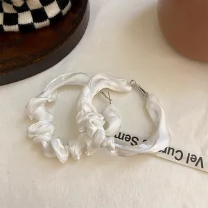 Detailansicht weißer geraffter Stoffohrringe mit elegantem plissiertem Texturdesign