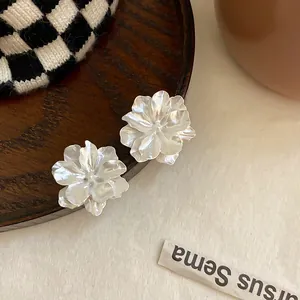 Detailansicht der weißen, geschichteten Blumenohrstecker mit eleganten Faltblattdetails