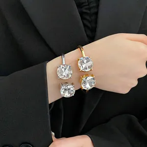 Close-up of elegant open cuff bracelets with large round crystals on model wrist