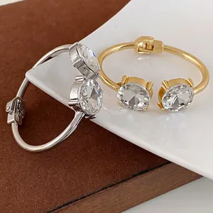 Close-up of gold and silver open bangles with large round clear crystals