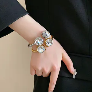 Macro view of gold and silver open bracelets with large round crystals