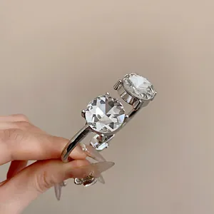 Close-up of elegant silver open bangle with two large faceted round crystals.