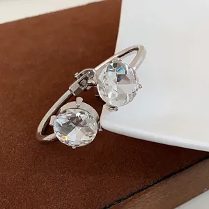 Macro view of two large round faceted crystals on a luxury silver-finish open bangle