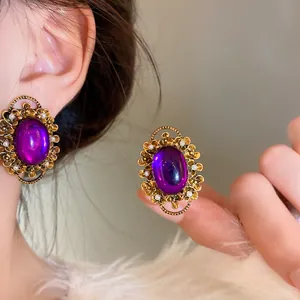 Detailed view of vintage French purple oval clip-on earrings with elegant pearl accents