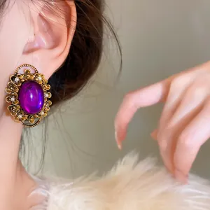 Elegant French vintage style purple oval ear clip with pearl details worn on ear