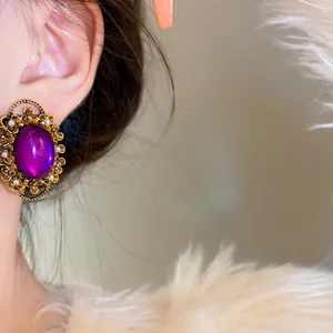 Close-up of vintage French style oval purple gem clip-on earring on ear