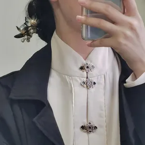 Close-up of a traditional Chinese hair stick featuring black petals and white pearls