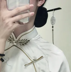 Detailed view of traditional Chinese hair stick with tassel and marble-style pendant