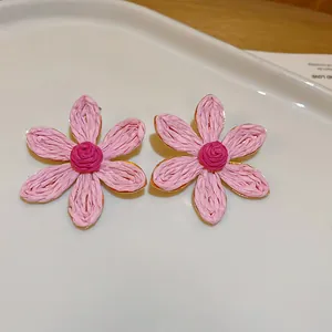 Handgefertigte rosa gewebte Bastblumen-Ohrstecker mit eleganten goldfarbenen Akzenten