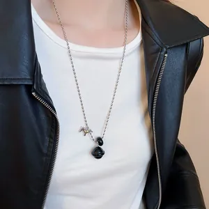 Detailweergave van een minimalistische paardenhanger aan een model met leren jas.